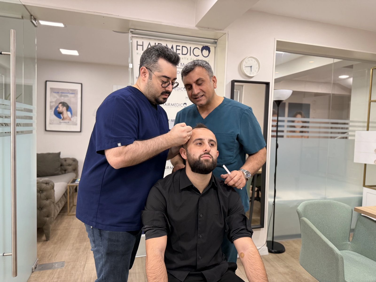 Dr. Arslan Musbeh examining a patient's scalp during consultation