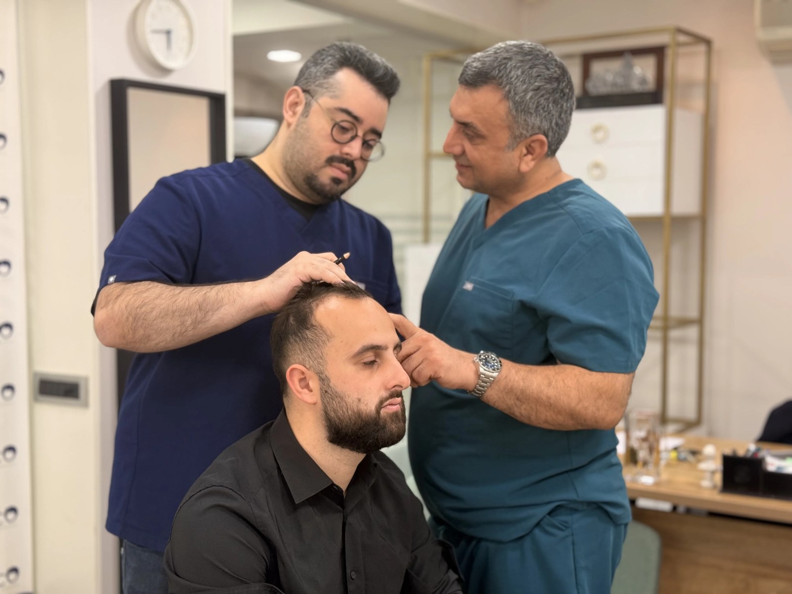 Dr. Arslan Musbeh examining a patient's scalp during consultation