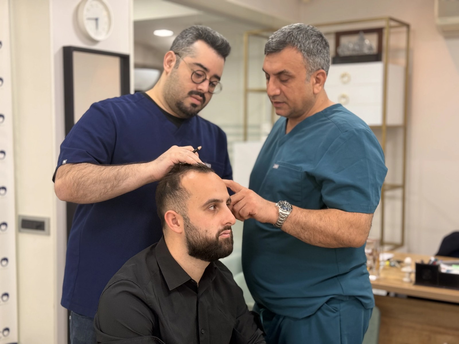 Dr. Arslan Musbeh examining a patient's scalp during consultation